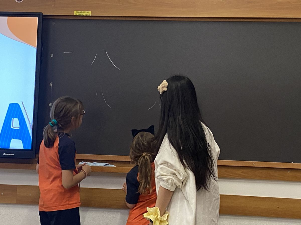 Students in Leone XIII uniform at the blackboard with their MIX teacher